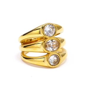 Detail of a triple-layered gold titanium ring featuring three bezel-set zircons on white