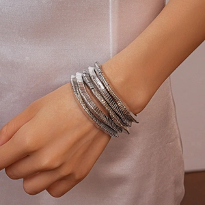 Macro detail of silver geometric multi-layer metal bracelet with textured snake chain surface