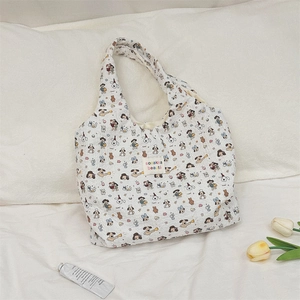Detail of white quilted canvas tote bag featuring cute cartoon dog prints and tulip decor