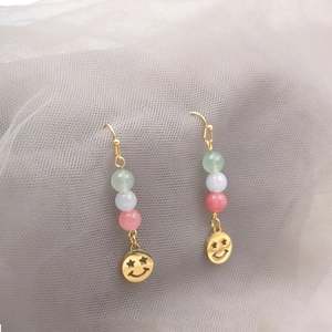 Ethnic style beaded earrings with green and purple jade beads and golden clown mask charms