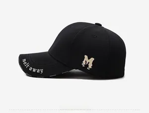 Detail of black baseball cap with beige M embroidery and melt away text on the brim