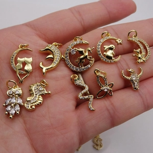 Micro-set zircon gold pendants featuring various animal shapes displayed on a palm