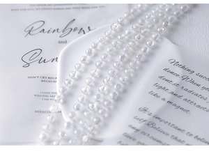 Close-up of elegant iridescent pearl beads with neon luster on white ceramic plate