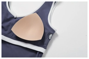 Detail of navy yoga bra featuring removable padding and white contrast piping finish