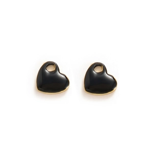 Detail of heart pendants with black enamel finish and gold metal edges on white background