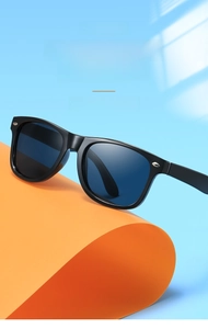 Détail de lunettes de soleil carrées pour enfants avec rivets argentés sur fond bleu et orange