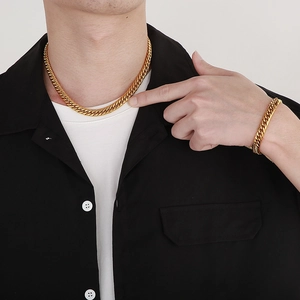 Vue détaillée d'un ensemble collier et bracelet maille gourmette dorée sur un mannequin