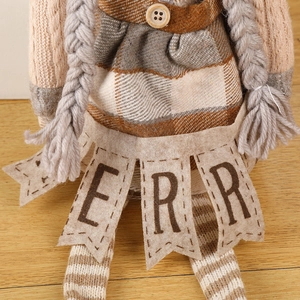 Christmas gnome doll with knitted details and Merry slogan on wooden background
