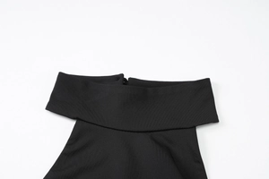 Close-up detail of the black boat neck collar and texture of the backless maxi dress