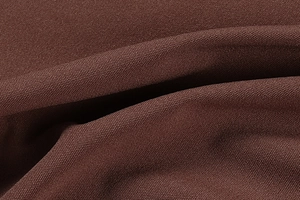 Gros plan du tissu tissé marron révélant une texture maille de qualité et des plis