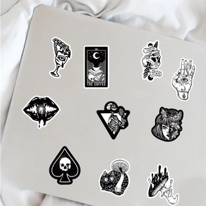Macro shot of 10 Gothic dark stickers in black and white on a silver laptop surface