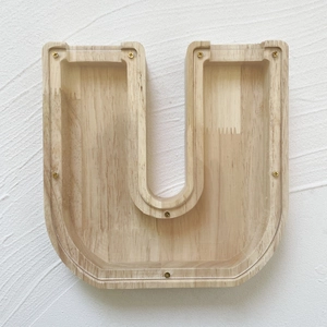 Macro shot of U-shaped oak money box with clear acrylic panel and gold screw details