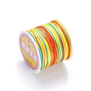 Macro shot of multi-colored gradient jewelry cord spool for DIY hand-woven bracelets