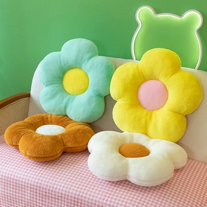 Cute flower-shaped plush cushions in four colors on a cozy sofa for home decor