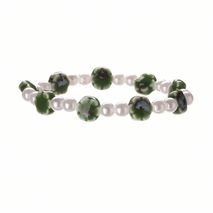 Close-up of beaded bracelet with white faux pearls and green ceramic flower charms