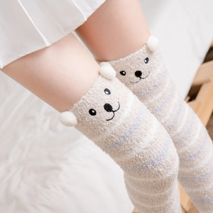 Detail of coral fleece over-knee socks with cute bear ears and striped plush texture