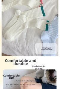 Detailed view of striped cotton crew socks with elastic cuffs and cute cartoon labels