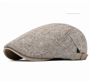 Detail of light khaki herringbone flat cap featuring textured fabric and side buckle adjustment