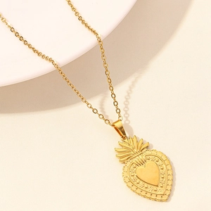 Detail of 18k gold plated sacred heart pendant with intricate relief on an O-chain necklace