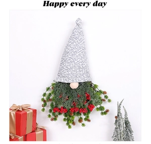 Détails d'un gnome de Noël suspendu avec baies rouges et aiguilles de pin synthétiques