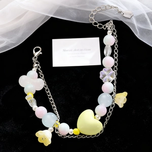 Detalle de pulsera de corazón doble capa con cuentas de cristal de colores y dijes de flores