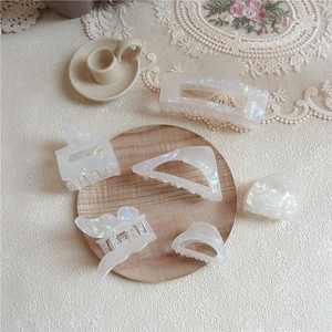 Close-up of iridescent pearlescent acetate hair claws in various geometric shapes