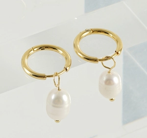 Detail of 18K gold stainless steel hoop earrings featuring natural white baroque pearls