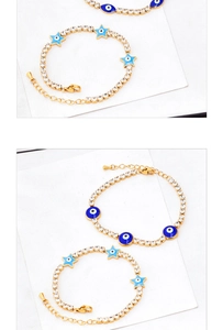 Detailed macro view of gold titanium steel bracelets with blue star and evil eye charms