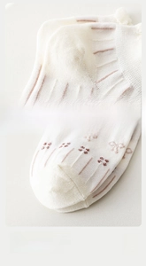 Detail of white cotton socks with pink stripes, lace trim, and reinforced heel seams