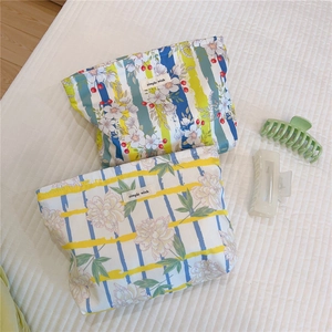 Detailed view of floral printed cotton cosmetic bags with Simple Wish label on white fabric