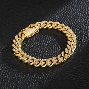Close-up of golden Cuban link bracelet with micro-pave crystals on black leather