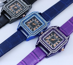 Makroaufnahme quadratischer Quarzuhren mit Diamantlünetten und Lederarmbändern in drei Farben