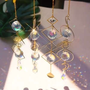 Detail of 4-piece golden crystal suncatchers with geometric frames and rainbow prisms