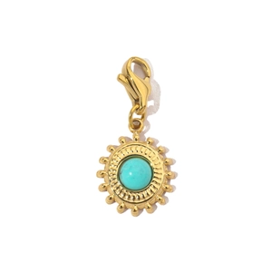 Detailed view of a sun-shaped gold pendant with turquoise stone and lobster clasp