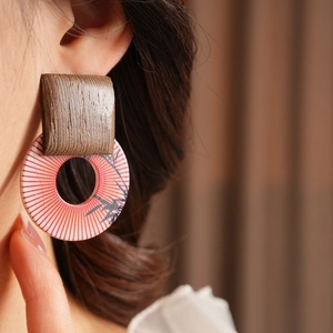 Detail view of model wearing vintage wooden geometric earrings with bamboo leaf print