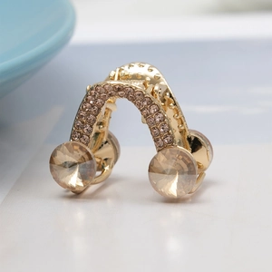 Macro d'une pince à cheveux dorée ornée de cristaux champagne et de strass étincelants