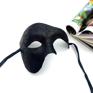 Close-up of black Phantom of the Opera half-face mask with glitter scroll patterns