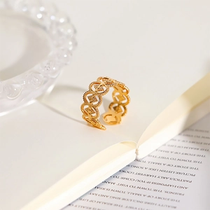 Detailed view of an 18k gold plated stainless steel ring with hollow circular patterns