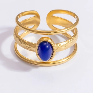 Detail of 18k gold triple-layer ring with an oval blue natural stone and retro texture