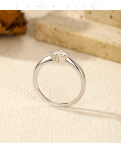 Macro shot of princess cut moissanite ring with classic four-prong silver setting