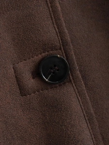 Detailed macro view of the brown faux suede jacket featuring a marbled button closure