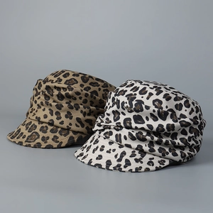 Detail view of leopard print baker boy hats in brown and beige with pleated design