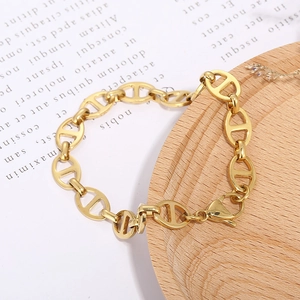 Minimalist gold stainless steel anchor link chain bracelet on a wooden base