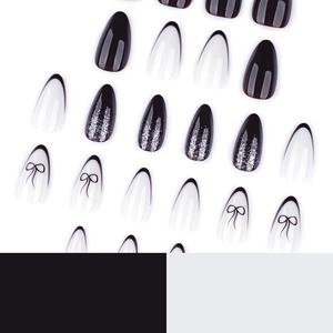Y2K almond press-on nails set in black, white French tips, and silver glitter bows