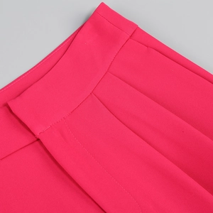 Detail of rose pink blazer suit with smooth fabric texture and crisp waist pleats
