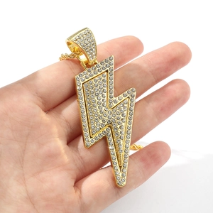 Close-up of golden lightning bolt pendant necklace encrusted with sparkling rhinestones
