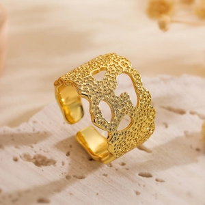 Gold plated geometric open ring with irregular texture on a stone background