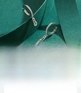 Close-up of S925 sterling silver safety pin earrings with 5A grade zircon micro-paving