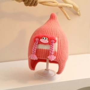 Detailed view of pink knitted baby hat with cute cartoon doll and long braided pigtails