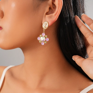 Detail of vintage gold-tone cameo earrings with purple crystals on a female model